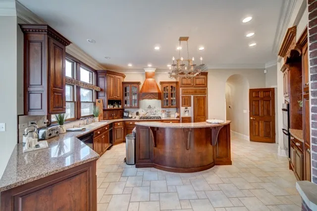 a large kitchen with stainless steel appliances granite countertop a large counter top and a stove