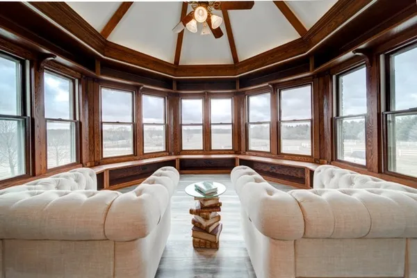 a living room with furniture and floor to ceiling windows