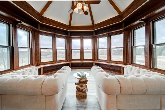 a living room with furniture and floor to ceiling windows