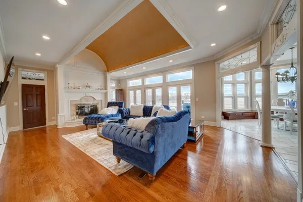 a living room with furniture a large window and wooden floor
