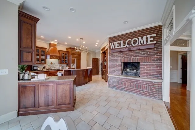 a living room with furniture a fireplace and kitchen view