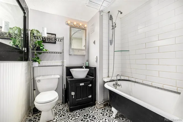 a bathroom with a granite countertop sink toilet and shower