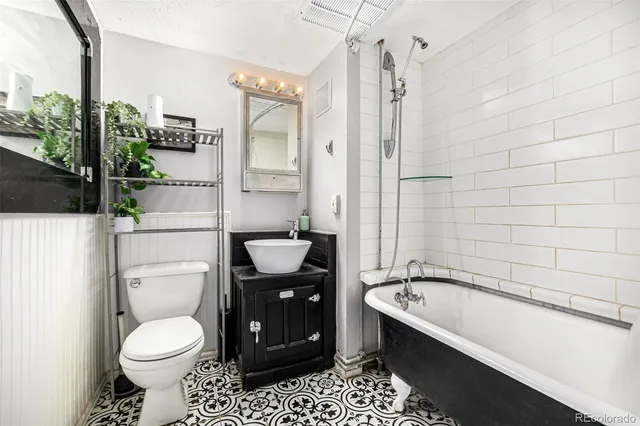 a bathroom with a granite countertop sink toilet and shower