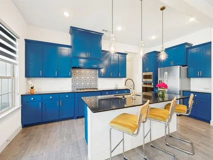 a kitchen with stainless steel appliances kitchen island granite countertop a sink and a cabinets