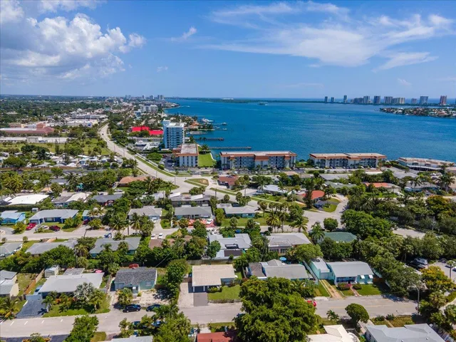 an aerial view of a city with lots of residential buildings ocean and mountain view in back