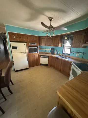 a kitchen with stainless steel appliances wooden floor dining table and chairs