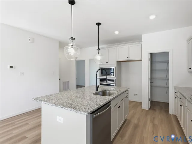 a kitchen with stainless steel appliances granite countertop a sink a refrigerator and a stove