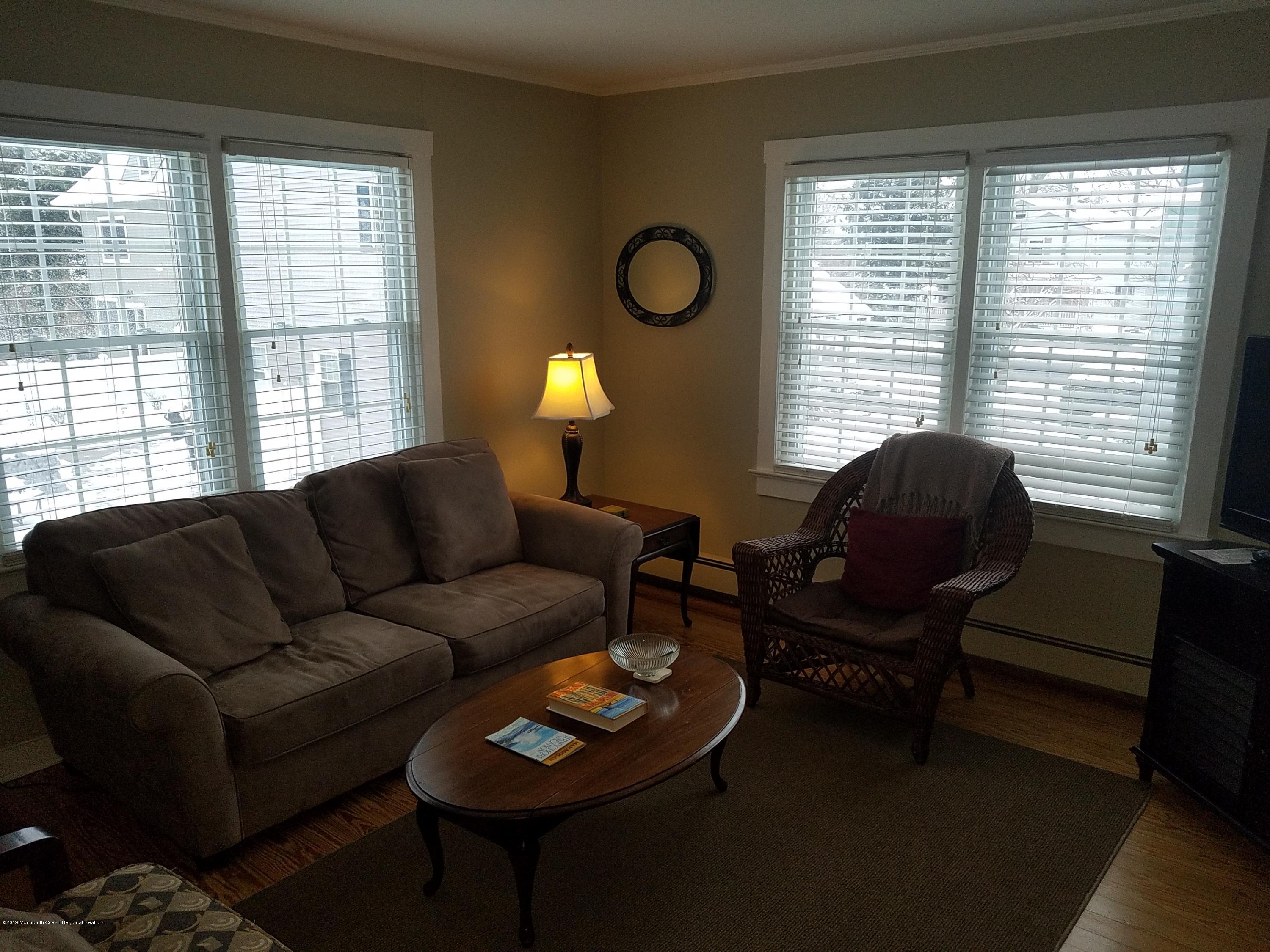 606 Ocean Road Spring Lake Heights, NJ 07762 - Photo 33 of 42 a living room with furniture and a lamp