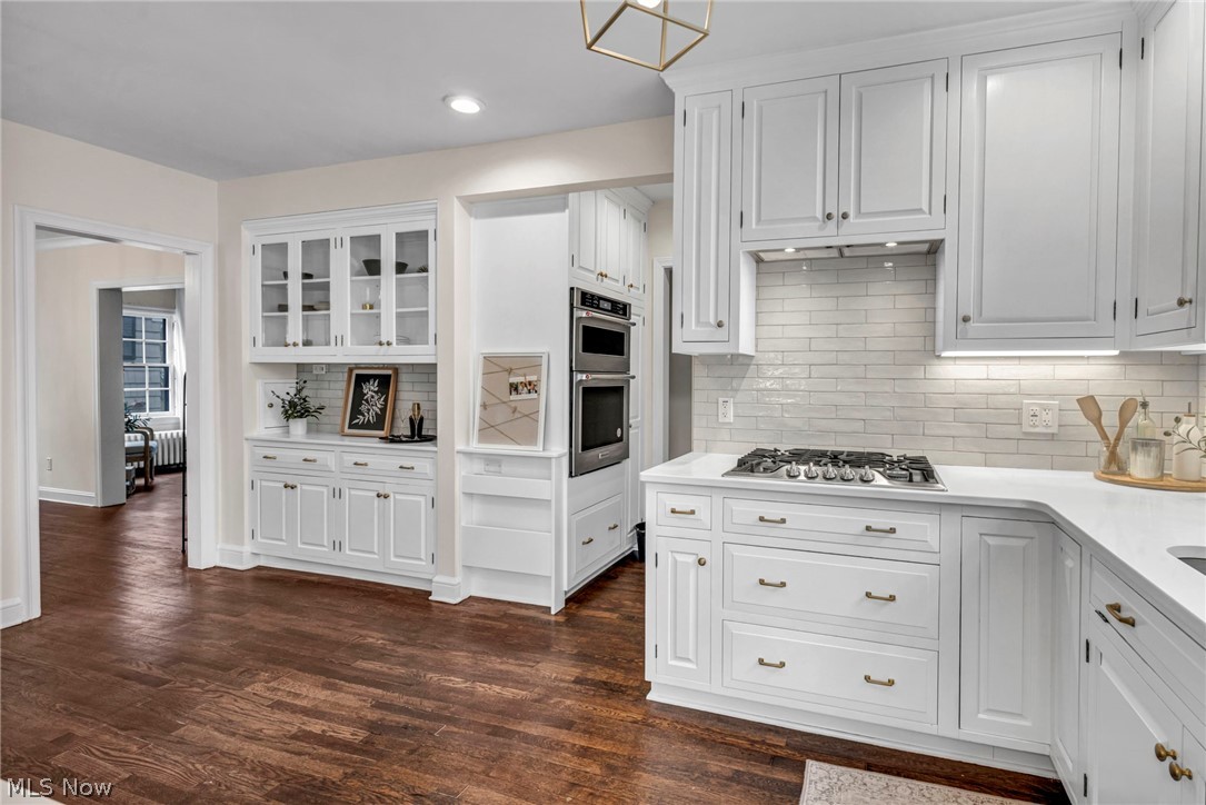 17409 Fernway Road Cleveland, OH 44120 - Photo 19 of 47 Kitchen with tasteful backsplash, white cabinetry, stainless steel appliances, and dark hardwood / wood-style floors