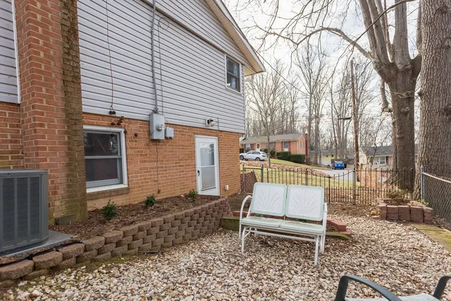 a backyard of a house with barbeque oven table and chairs
