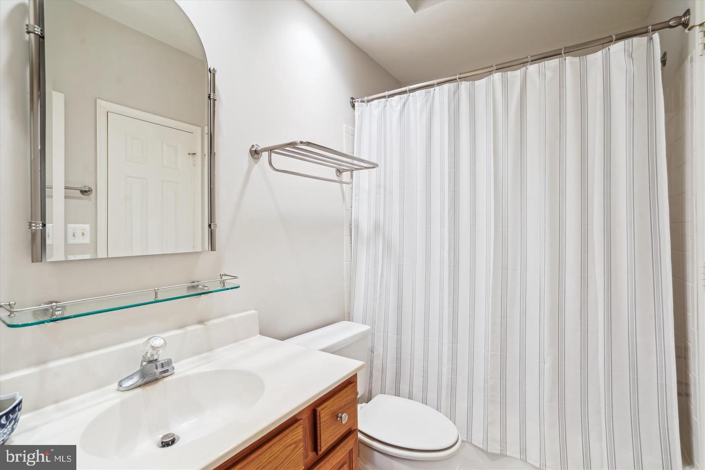 1334 Garden Wall Circle, Unit C Reston, VA 20194 - Photo 17 of 22 a bathroom with a sink a toilet and shower curtain