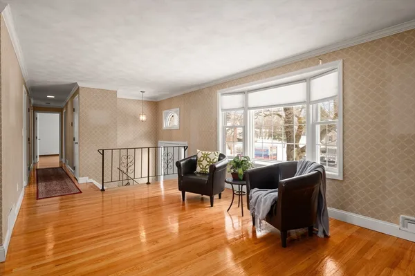 a living room with furniture floor to ceiling window and wooden floor