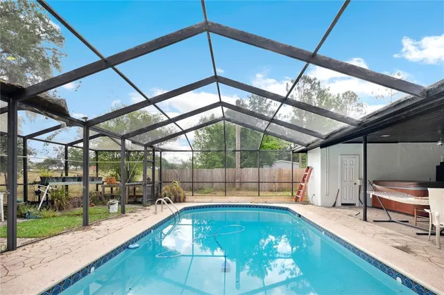 an aerial view of a house with yard and swimming pool
