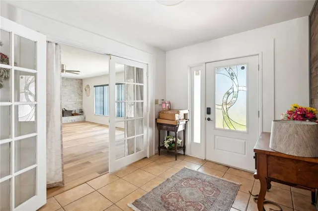 a view of a livingroom with a fireplace a ceiling fan and wooden floor