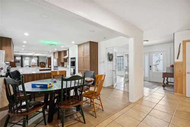 a dining room with furniture a chandelier and window