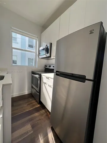 a kitchen with white cabinets and white appliances