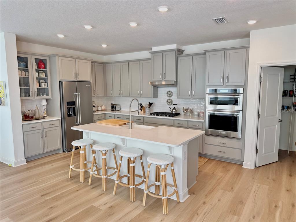 36 Signet Circle Flagler Beach, FL 32136 - Photo 8 of 45 a kitchen with stainless steel appliances a microwave a stove a refrigerator and a dining table with wooden floor