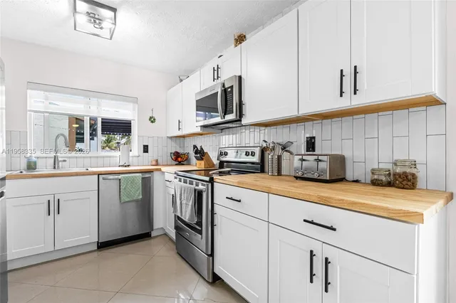 a kitchen with white cabinets and white appliances