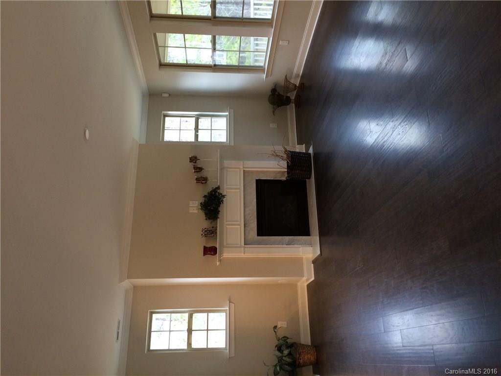 121 Helton Lane, Unit 47 Fort Mill, SC 29708 - Photo 18 of 20 an empty room with wooden floor and a fireplace