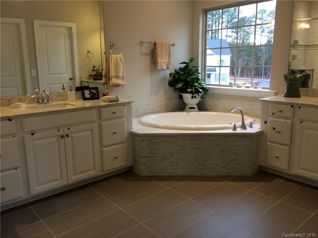 121 Helton Lane, Unit 47 Fort Mill, SC 29708 - Photo 8 of 20 a bathroom with a sink a large mirror and a bathtub