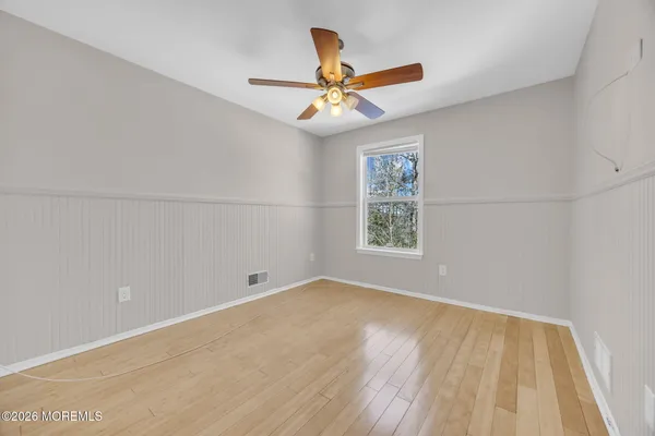 an empty room with windows and fan