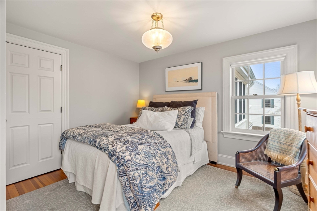 9 Windemere Park Manchester, MA 01944 - Photo 21 of 31 a bedroom with a bed and a chandelier