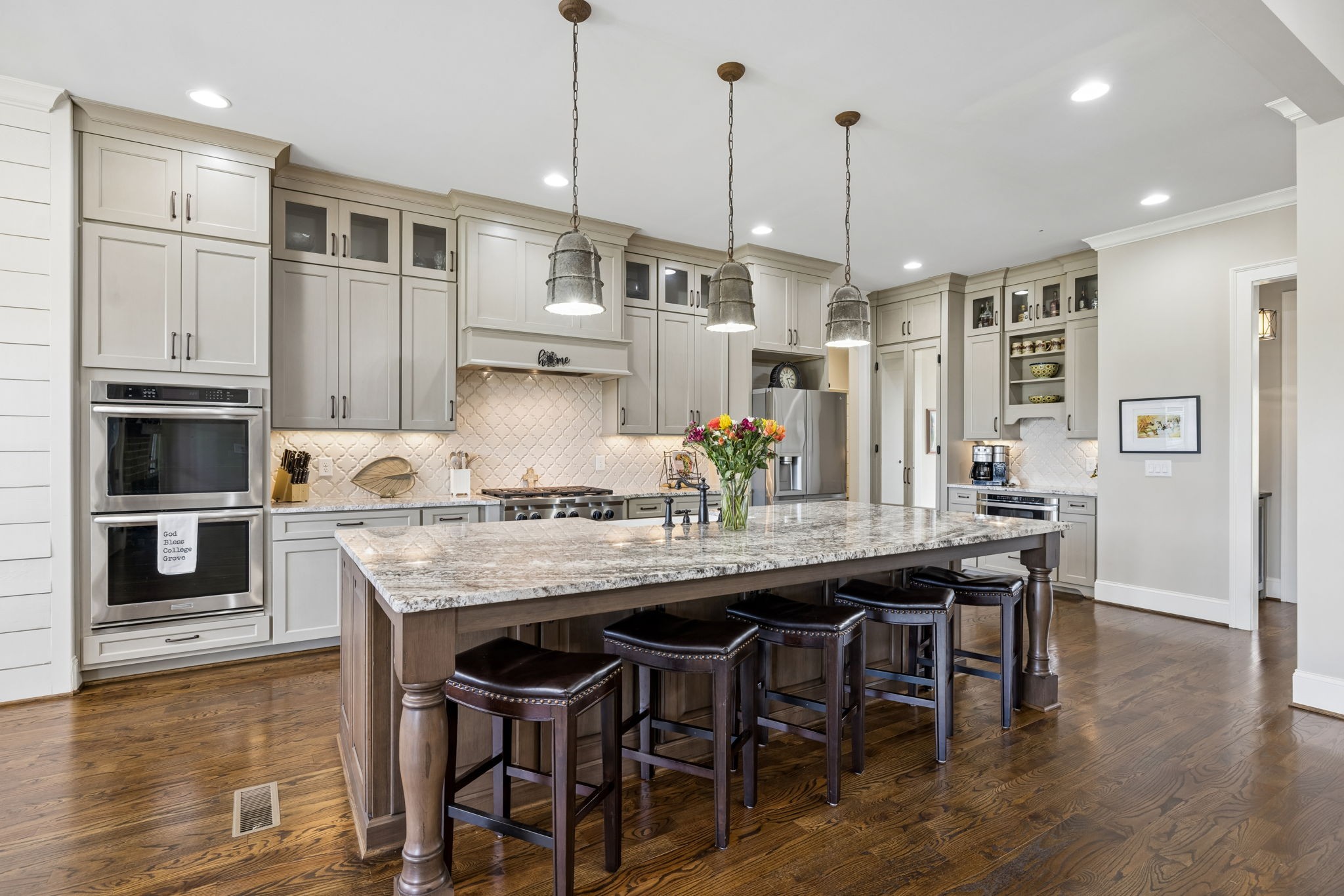 6033 Native Pony Trail College Grove, TN 37046 - Photo 27 of 87 a kitchen with stainless steel appliances granite countertop a table chairs stove and kitchen island
