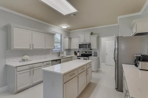 a kitchen with a sink a stove a refrigerator and cabinets