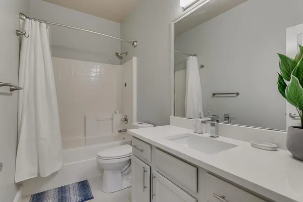a bathroom with a sink toilet double vanity and shower