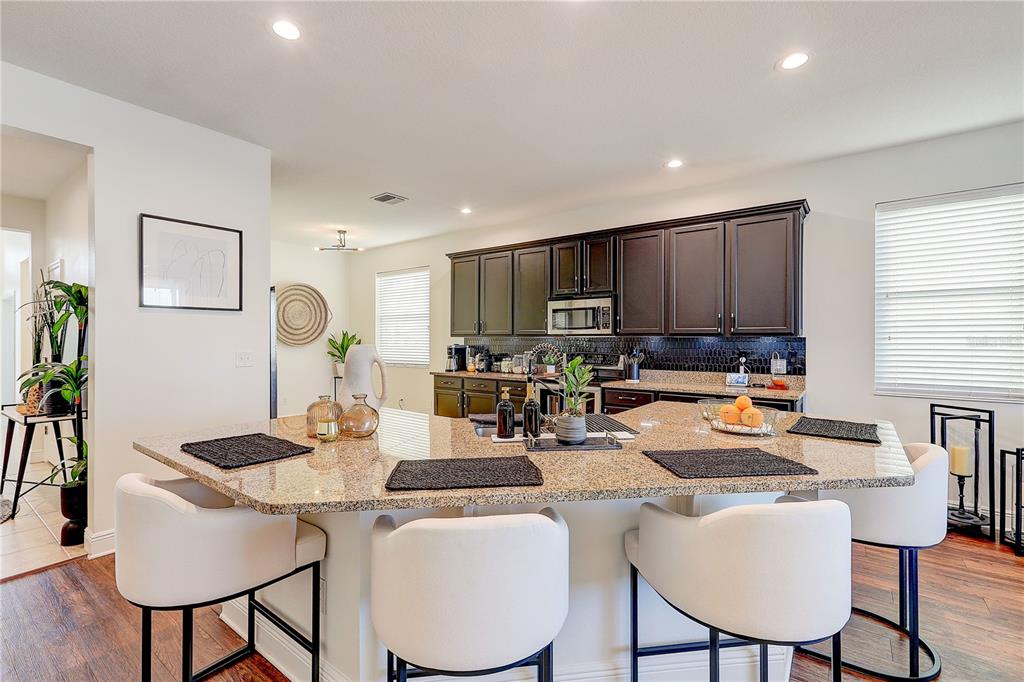 2410 Hawks Point Court Ruskin, FL 33570 - Photo 18 of 82 a kitchen with a dining table chairs and a refrigerator