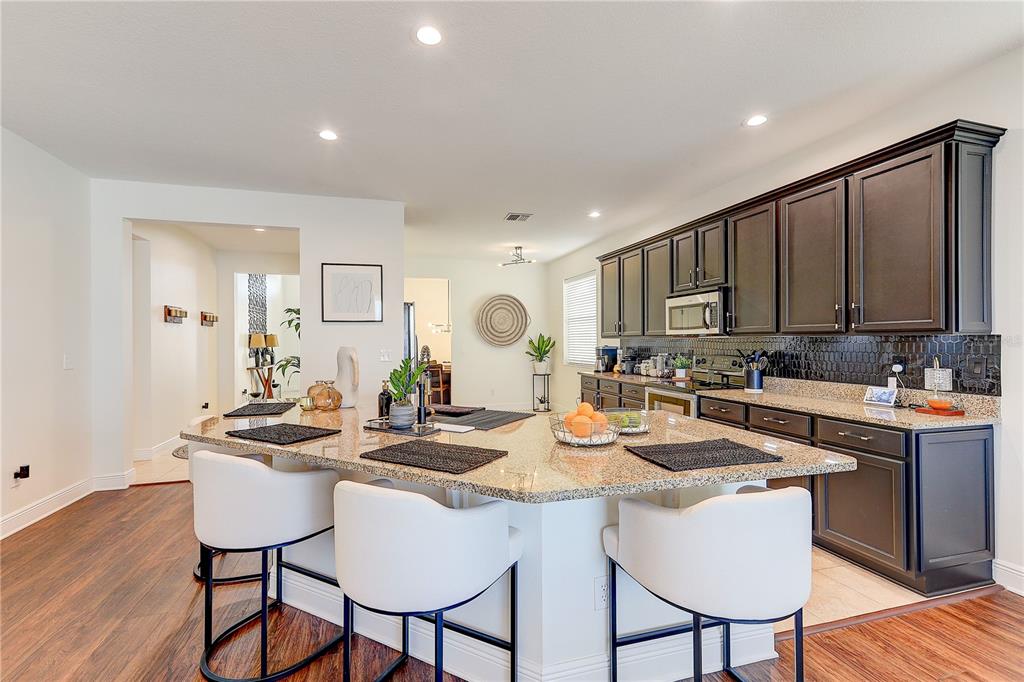 2410 Hawks Point Court Ruskin, FL 33570 - Photo 19 of 82 a kitchen with a dining table chairs and wooden floor