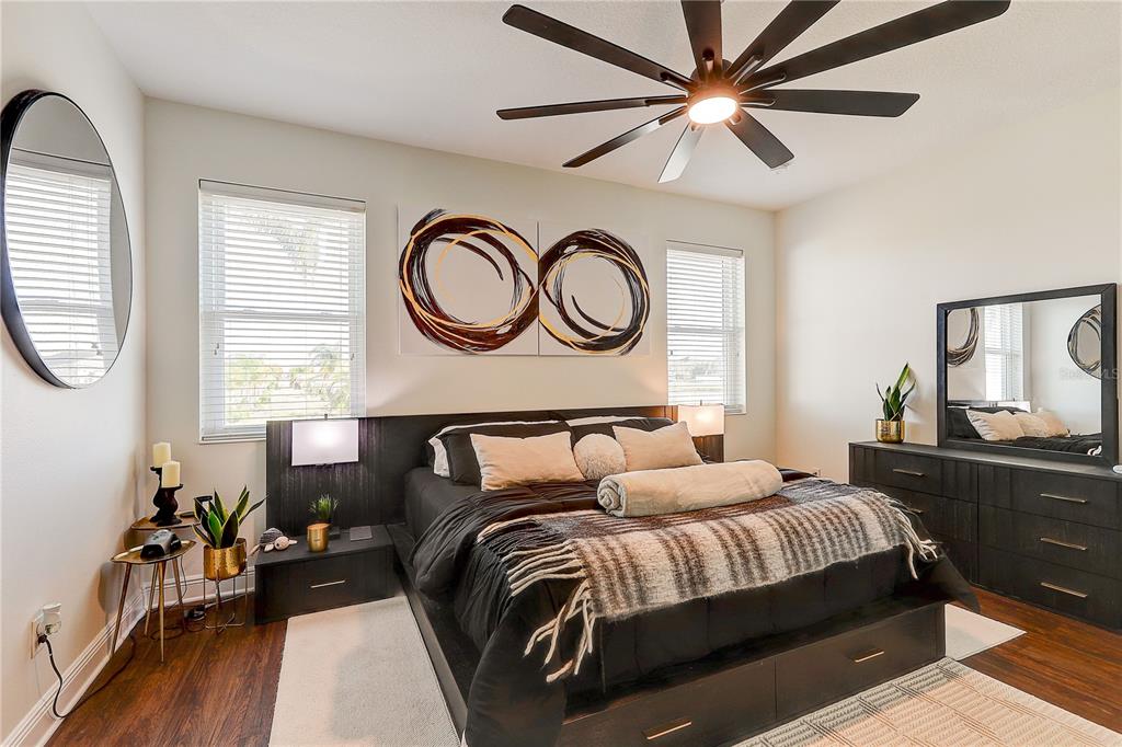 2410 Hawks Point Court Ruskin, FL 33570 - Photo 30 of 82 a bedroom with a bed a dresser next to a window with wooden floor