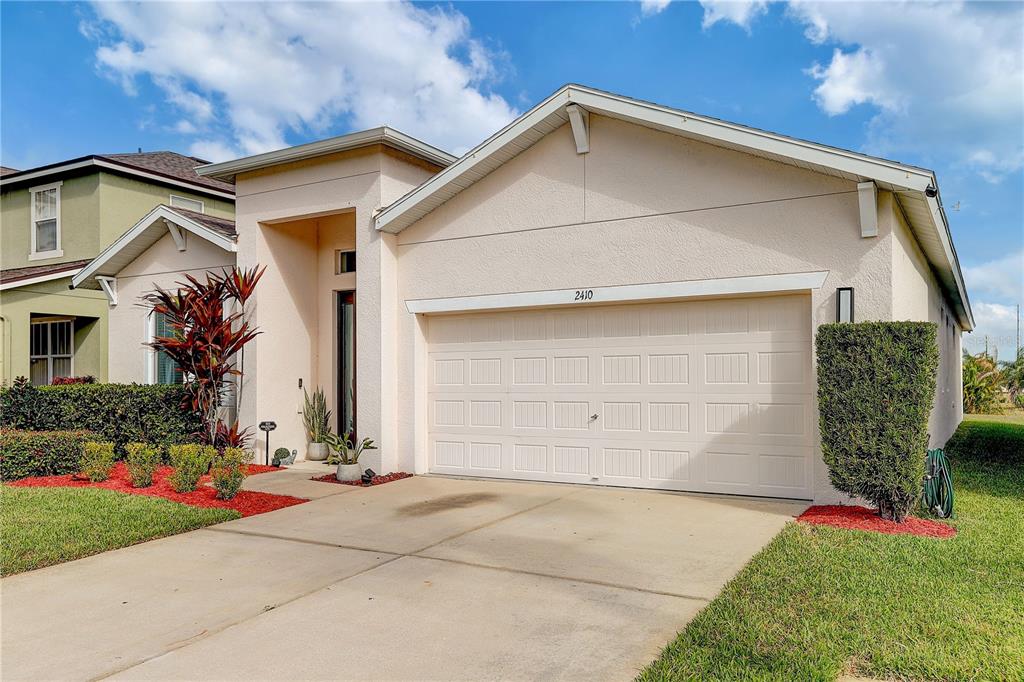 2410 Hawks Point Court Ruskin, FL 33570 - Photo 81 of 82 a front view of a house with a yard and garage