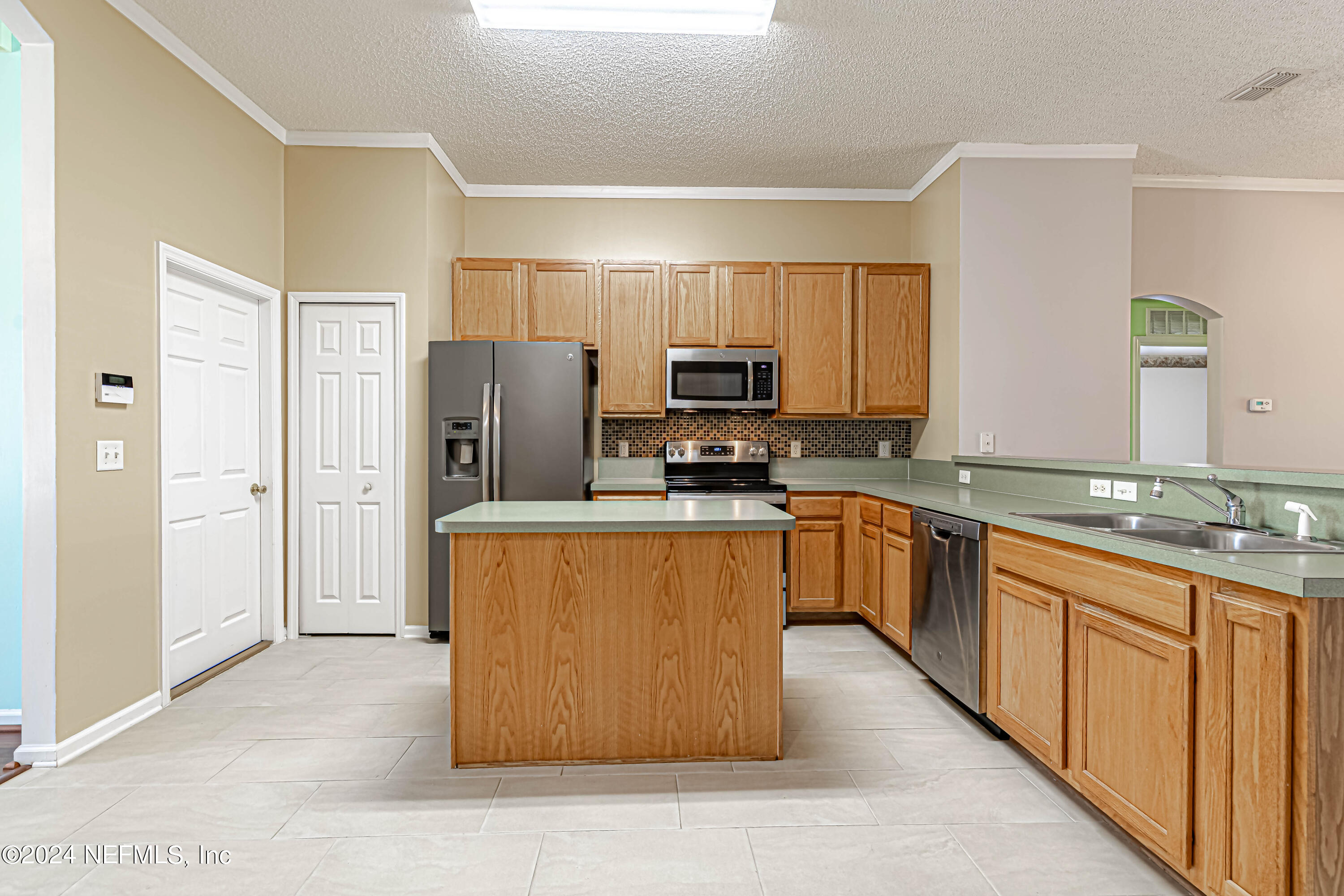 9380 Lockheed Lane Jacksonville, FL 32221 - Photo 15 of 40 a large kitchen with stainless steel appliances granite countertop a stove top oven a refrigerator a sink and dishwasher