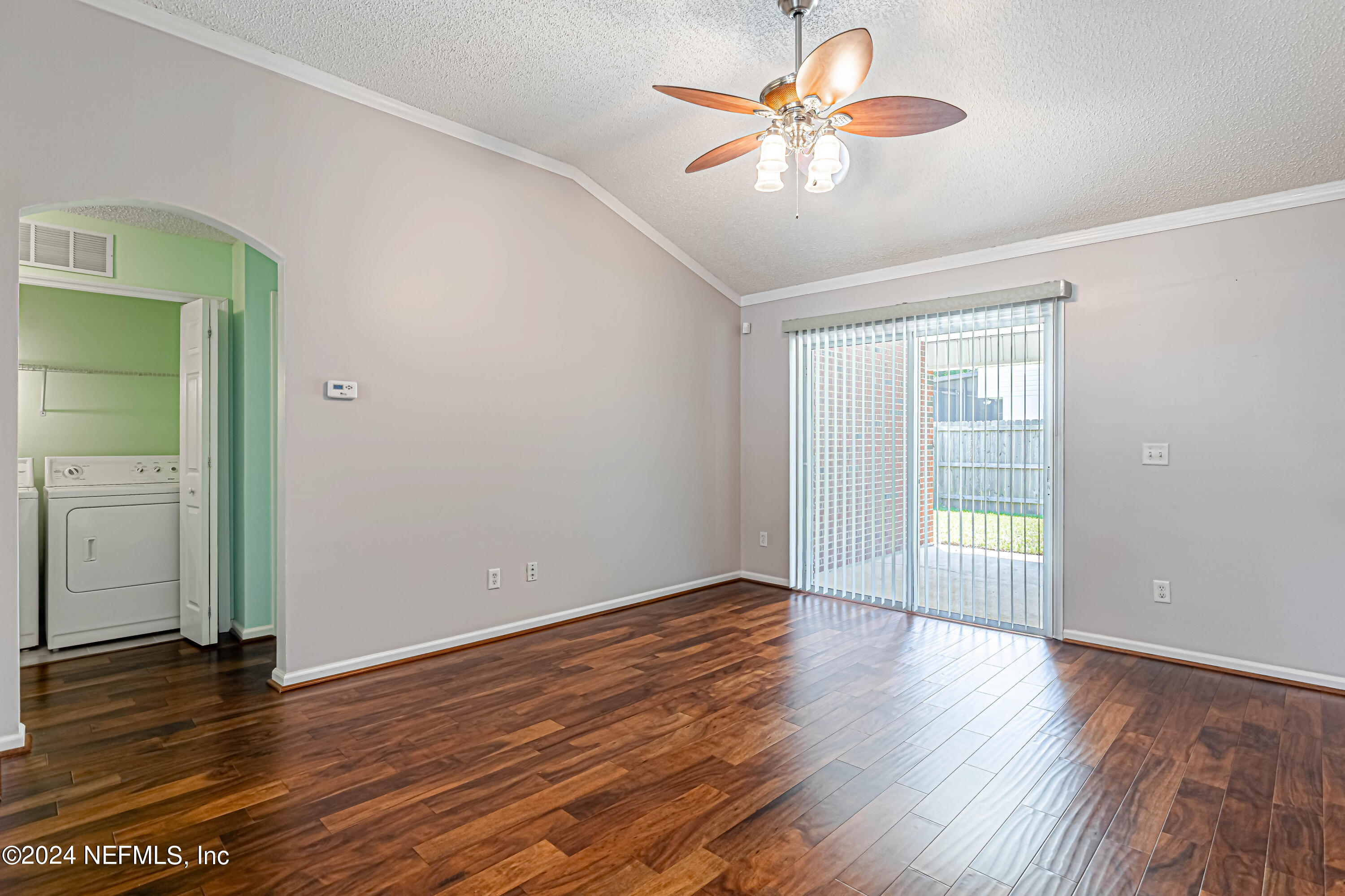 9380 Lockheed Lane Jacksonville, FL 32221 - Photo 18 of 40 an empty room with wooden floor chandelier fan and windows