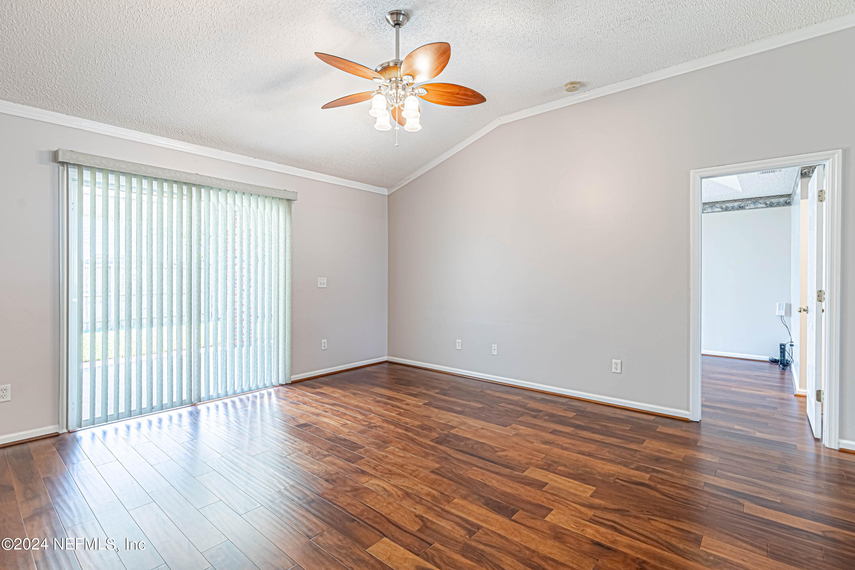 9380 Lockheed Lane Jacksonville, FL 32221 - Photo 21 of 40 an empty room with wooden floor and windows with curtains