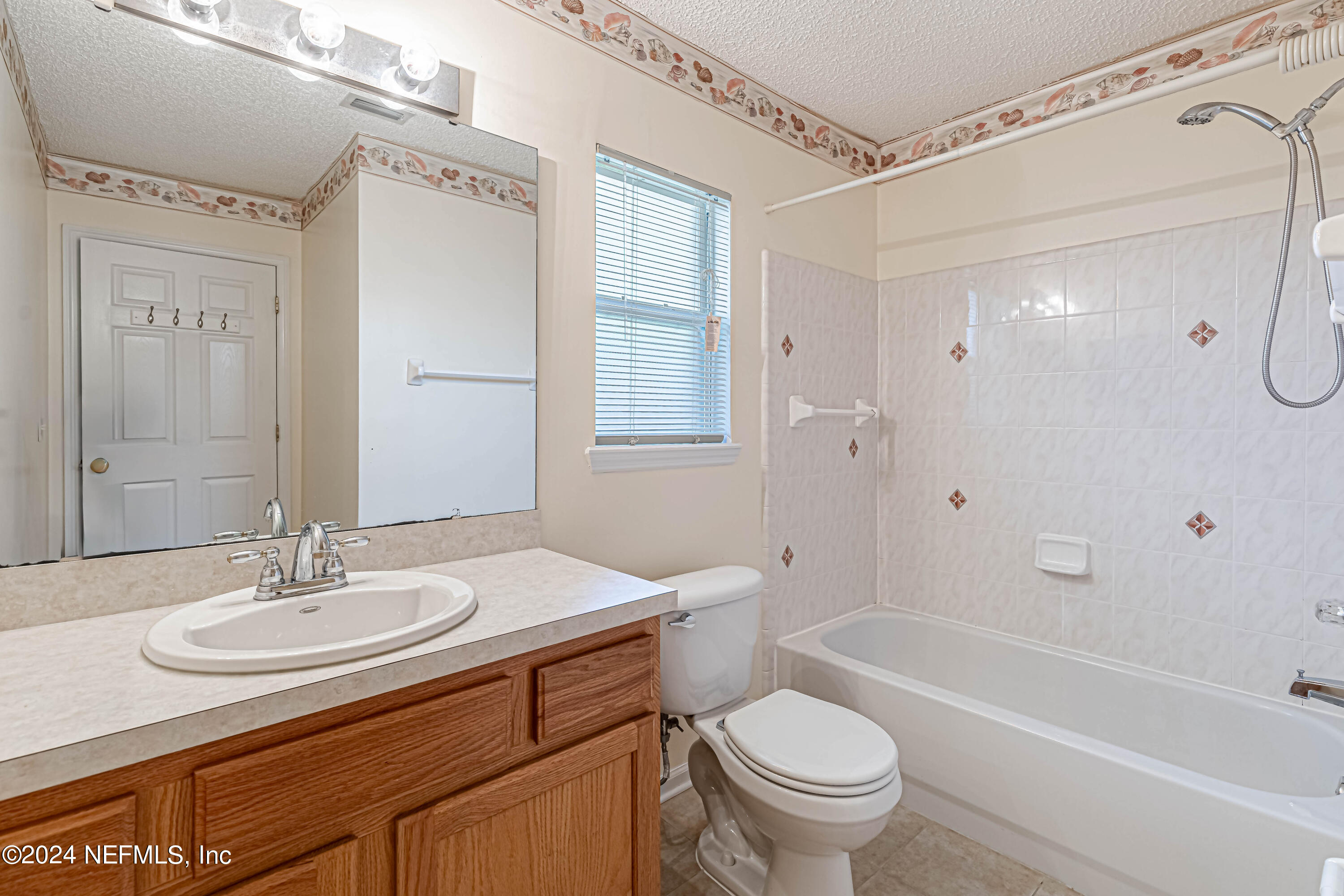 9380 Lockheed Lane Jacksonville, FL 32221 - Photo 25 of 40 a bathroom with a granite countertop sink a toilet a mirror a shower and a bathtub