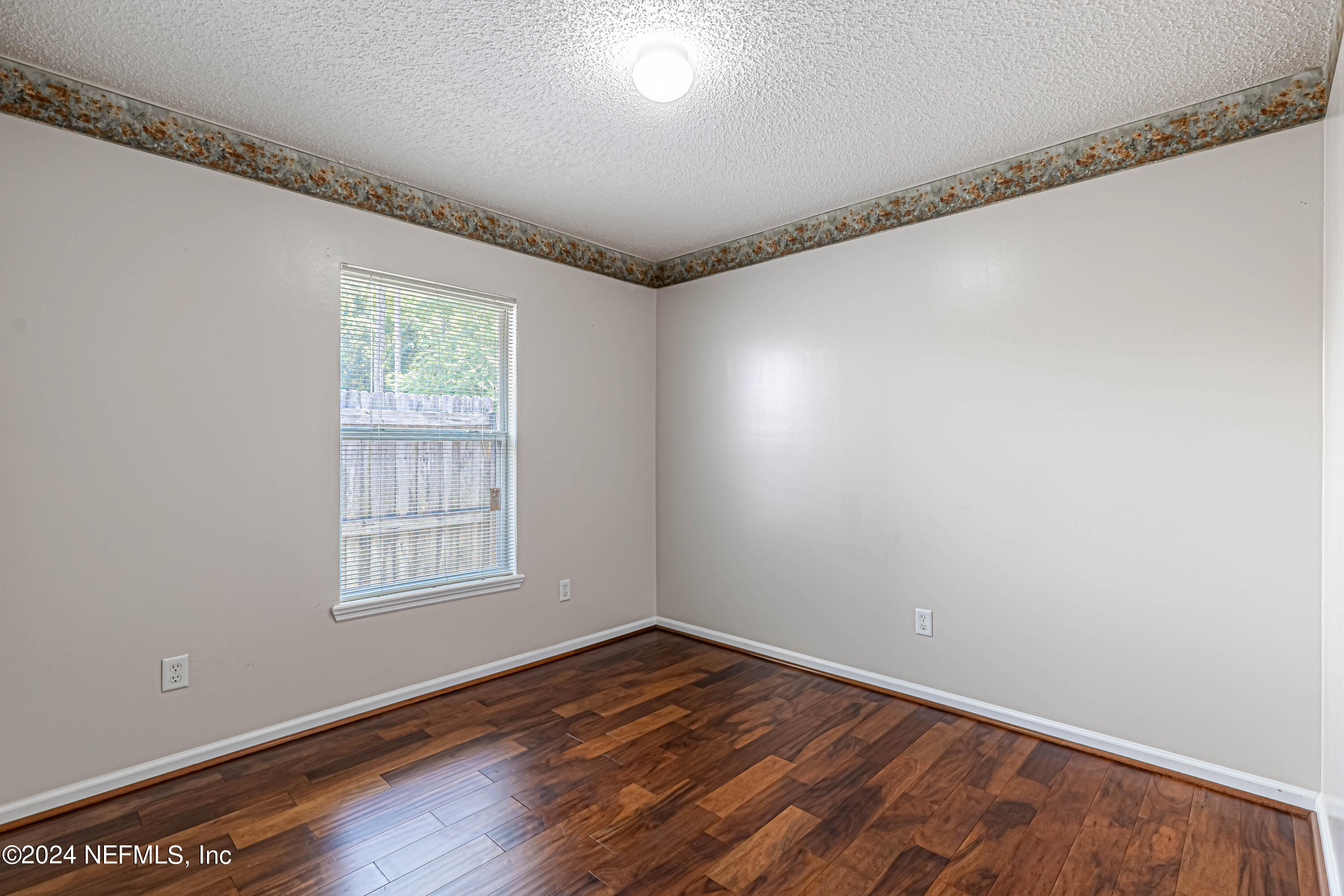 9380 Lockheed Lane Jacksonville, FL 32221 - Photo 26 of 40 a view of an empty room with wooden floor and a window