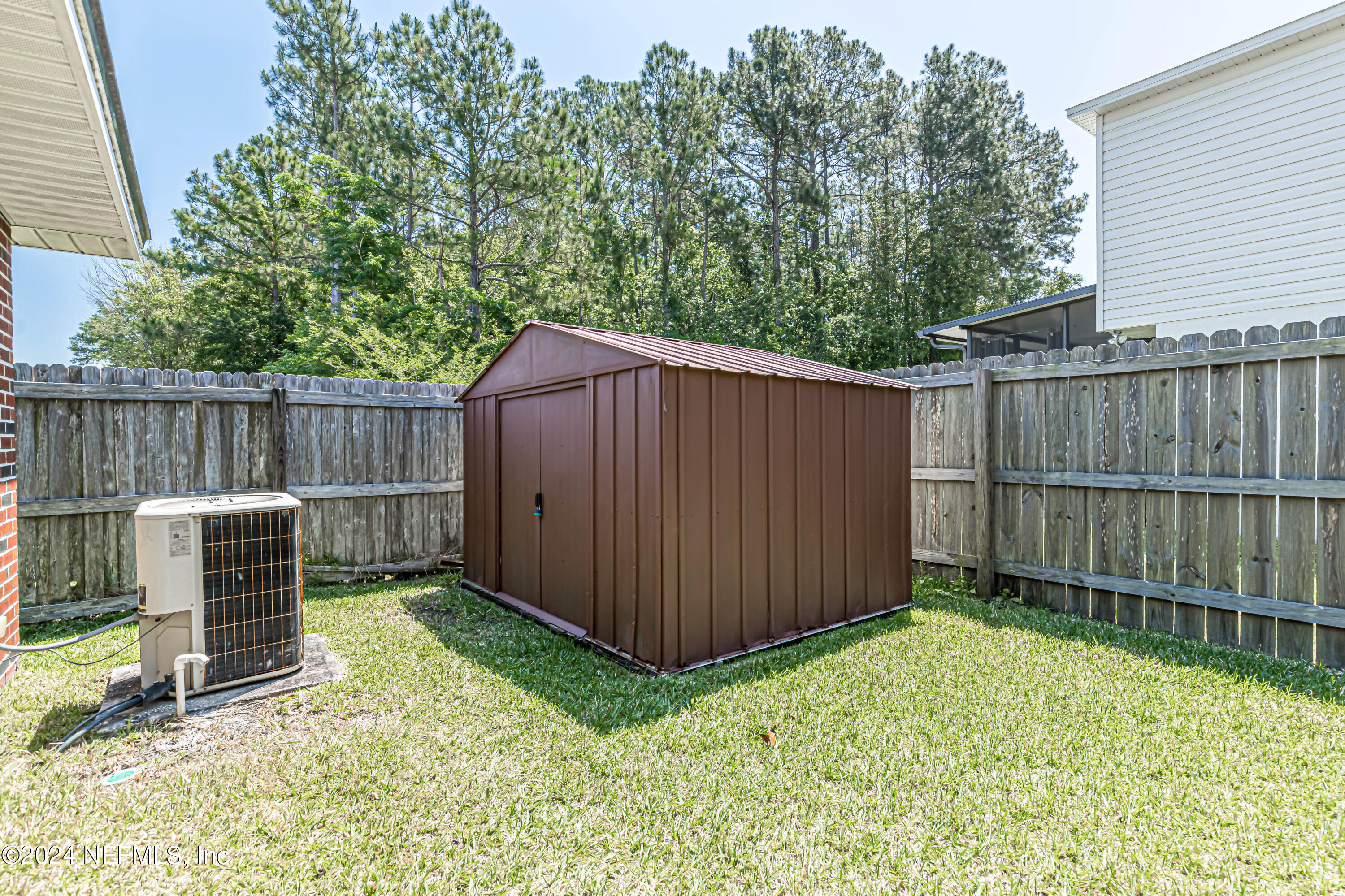 9380 Lockheed Lane Jacksonville, FL 32221 - Photo 38 of 40 a backyard of a house with lawn chairs and wooden fence