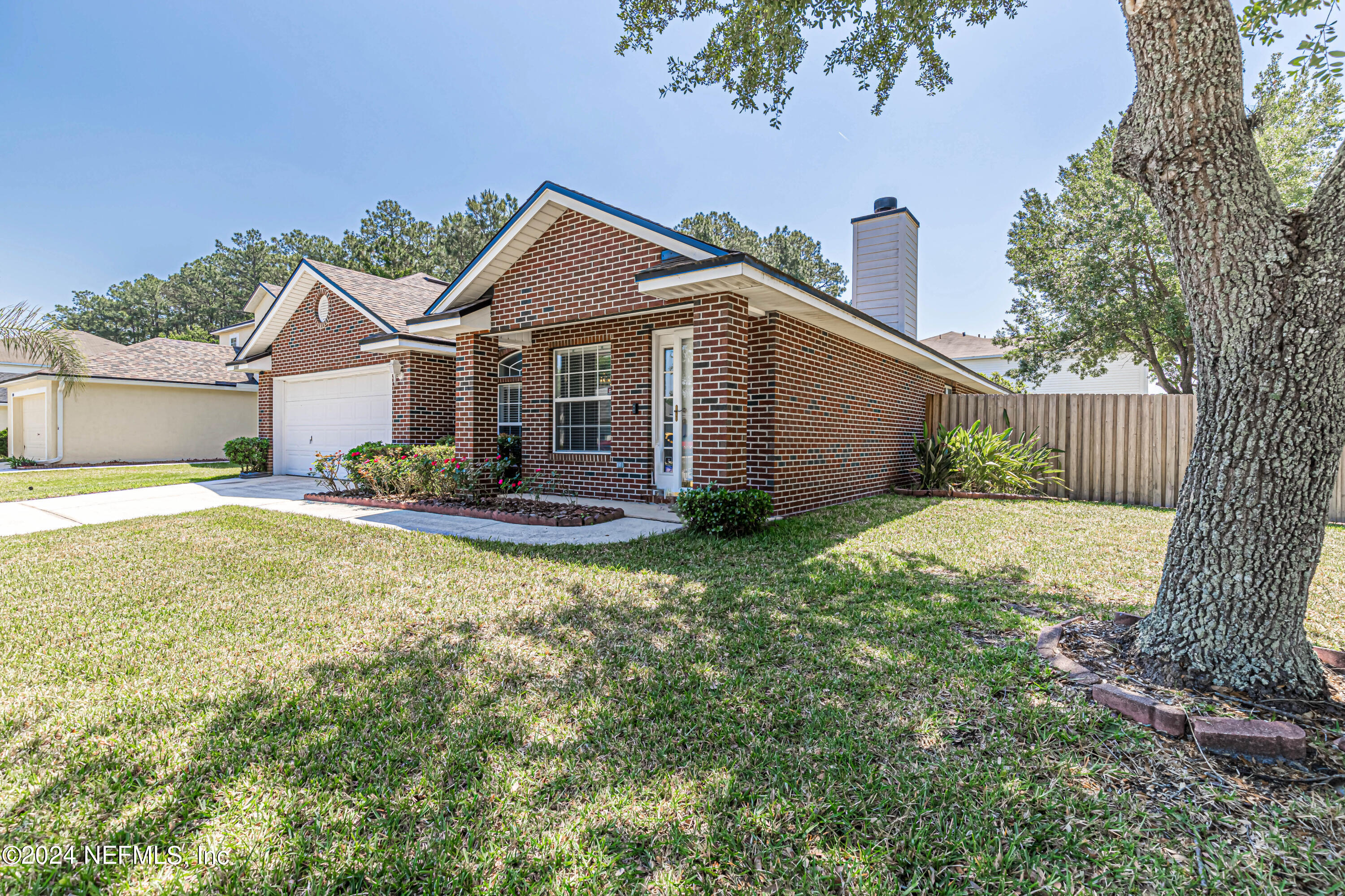 9380 Lockheed Lane Jacksonville, FL 32221 - Photo 6 of 40 a front view of a house with a yard and potted plants