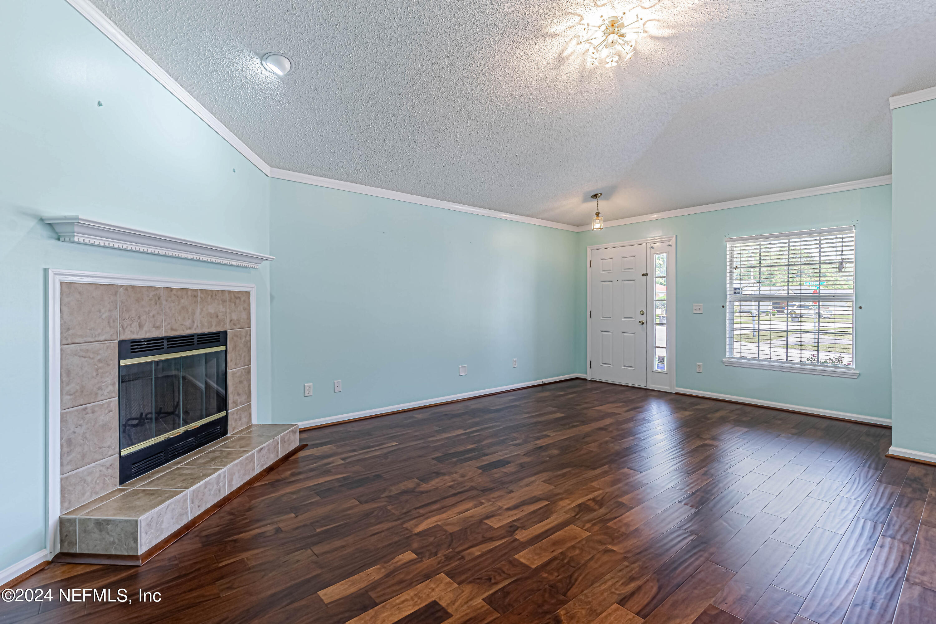 9380 Lockheed Lane Jacksonville, FL 32221 - Photo 10 of 40 a view of an empty room with wooden floor fireplace and a window