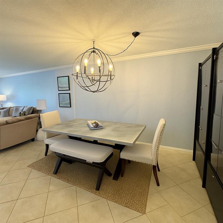 1000 Spanish River Road, Unit 3G Boca Raton, FL 33432 - Photo 12 of 31 a living room with a table and a chandelier