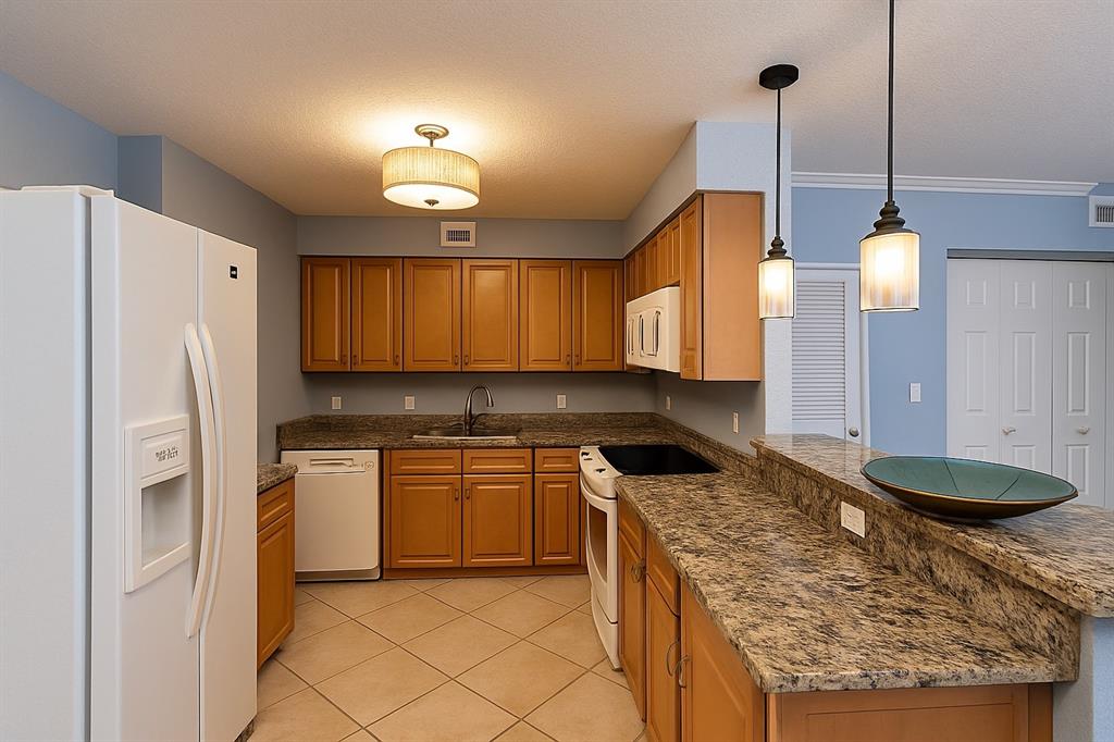 1000 Spanish River Road, Unit 3G Boca Raton, FL 33432 - Photo 16 of 31 a kitchen with stainless steel appliances granite countertop a sink a stove and a refrigerator