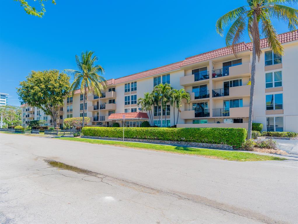 1000 Spanish River Road, Unit 3G Boca Raton, FL 33432 - Photo 3 of 31 a view of a house with a yard and palm trees