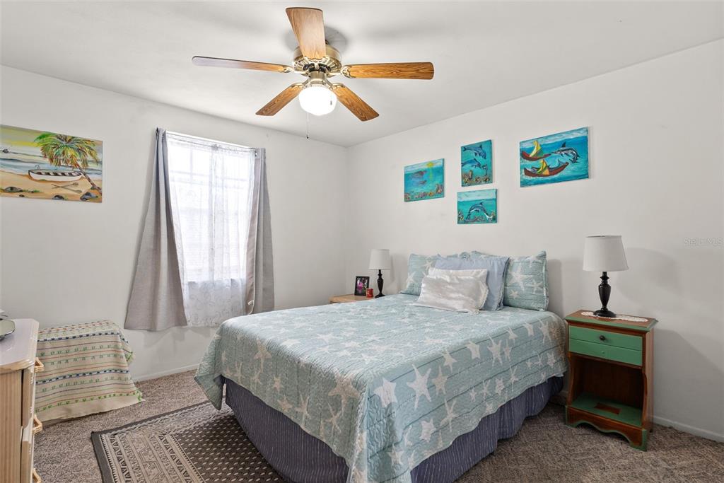 4227 Rax Place, Unit 4227 New Port Richey, FL 34652 - Photo 13 of 42 a bedroom with a bed and a chandelier