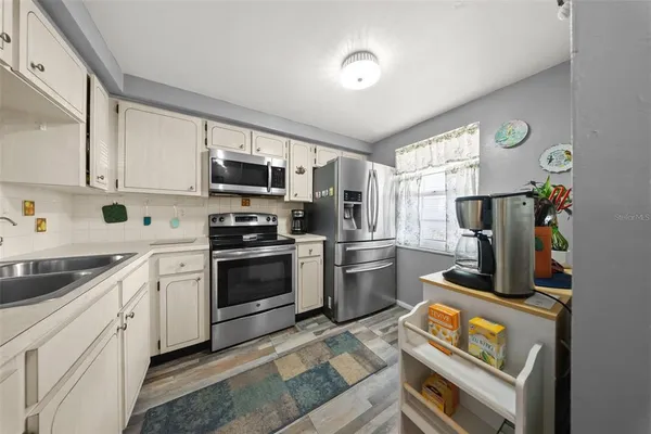 a kitchen with white cabinets and black appliances