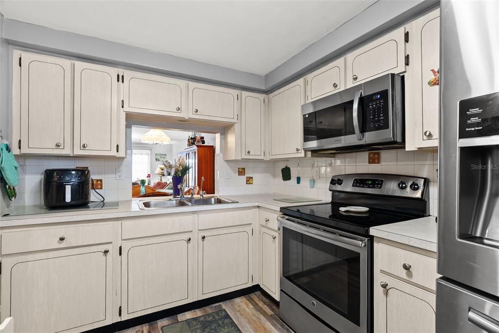 4227 Rax Place, Unit 4227 New Port Richey, FL 34652 - Photo 9 of 42 a kitchen with white cabinets and black appliances