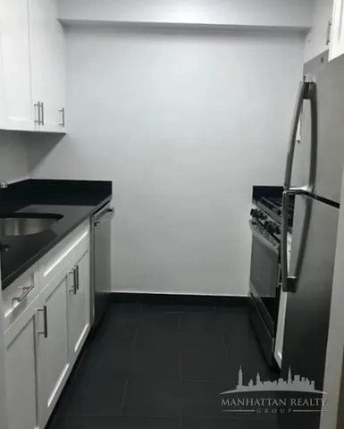 a kitchen with a sink a refrigerator and window