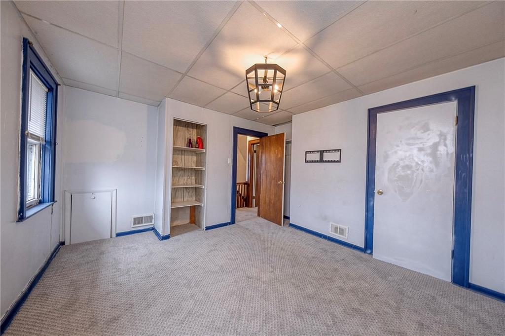 2399 Beaver Road Ambridge, PA 15003 - Photo 14 of 24 an empty room with a chandelier fan and windows