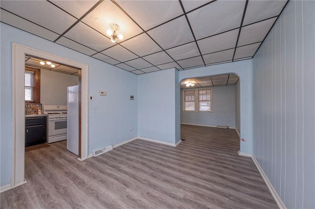 2399 Beaver Road Ambridge, PA 15003 - Photo 6 of 24 a view of an empty room with wooden floor and a kitchen